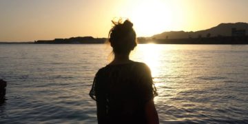 2e0a1cf1e0e4fffe445f937ad2c2ec24 silhouette of woman sitting on the beach stock video footage 1920
