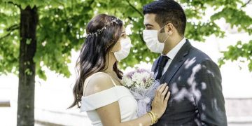 Bride and groom in a face protection mask