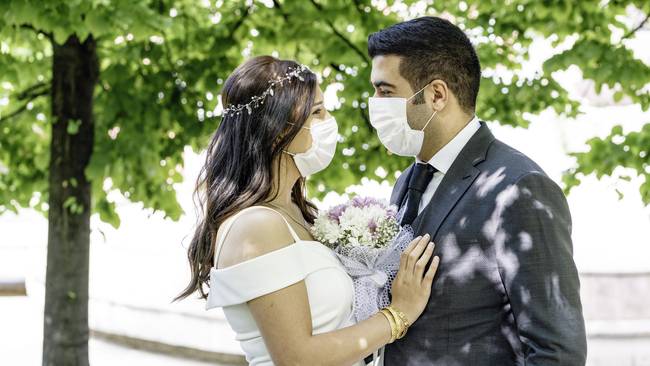 Bride and groom in a face protection mask